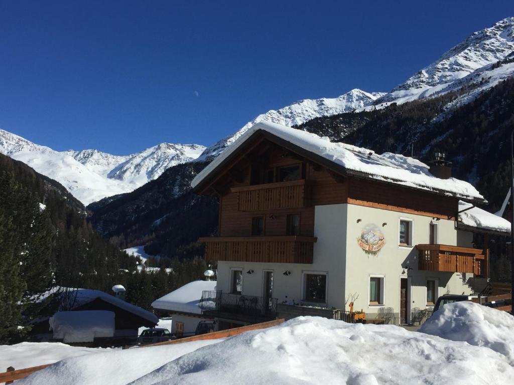 ein Gebäude im Schnee mit Bergen im Hintergrund in der Unterkunft Chalet Bucaneve in Santa Caterina Valfurva