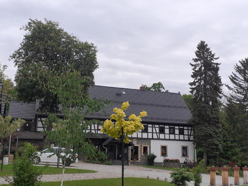 a black and white house with a tree in front of it at Agroturystyka Łysa Góra in Jelenia Góra