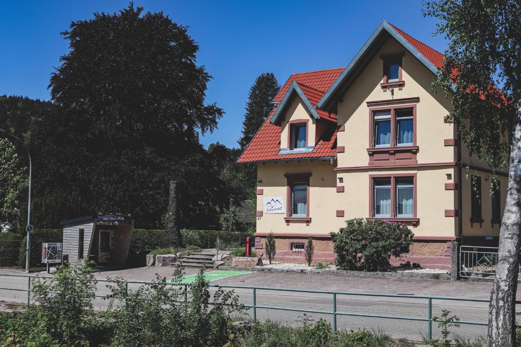 a large house with a red roof at Pension Heimat in Ottenhöfen