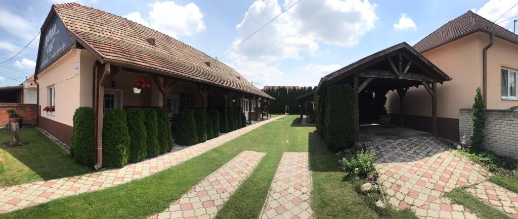 a house with a green yard next to a building at Apartman u Karla in Veľký Meder