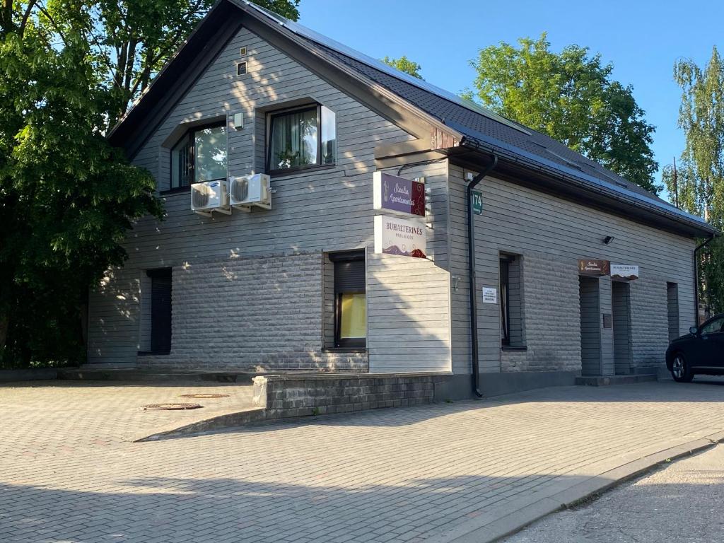 un bâtiment avec une voiture garée devant lui dans l'établissement Šiauliu apartamentai, à Šiauliai