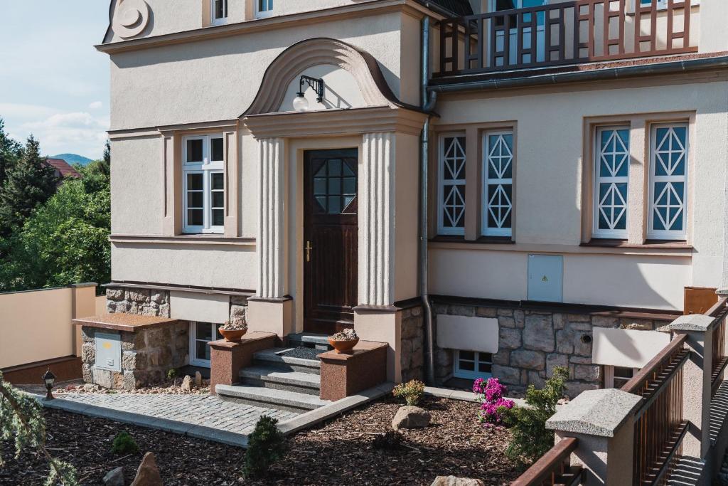 ein Haus mit einer Holztür und einer Treppe davor in der Unterkunft Penzion U Pivovaru in Děčín