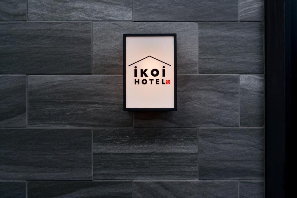 ikoi HOTEL في كيوتو: علامة على فندق على جدار حجري