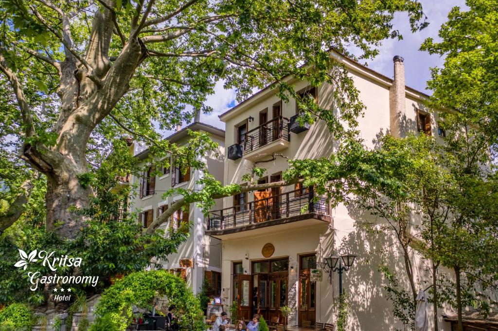 una casa bianca con balcone e alberi di Gastronomy Hotel Kritsa a Portariá