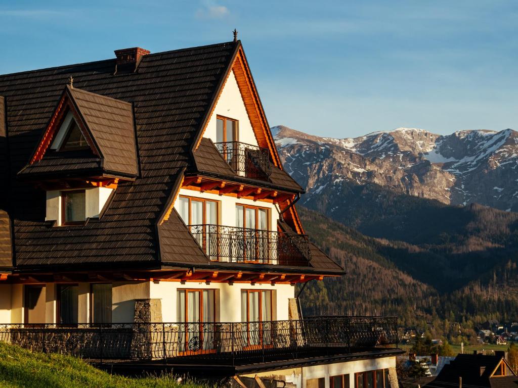 a house on a hill with mountains in the background at Strama Kościelisko in Kościelisko