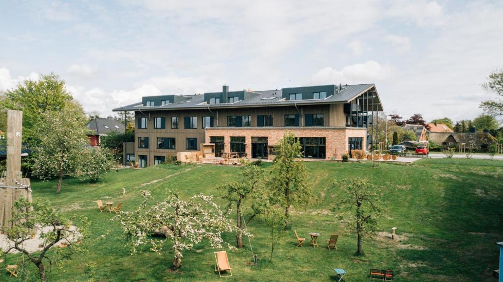 una grande casa su una collina con giardino di Hotel Landhafen a Niebüll