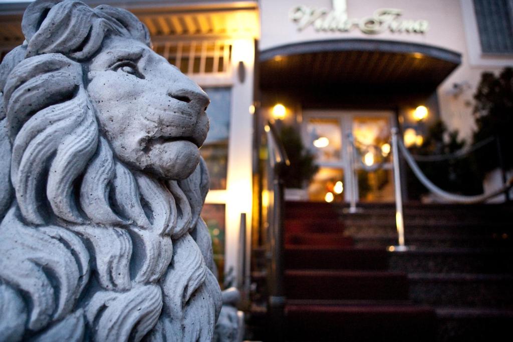 una statua di leone di pietra di fronte a un edificio di Hotel Vila Tina a Zagabria