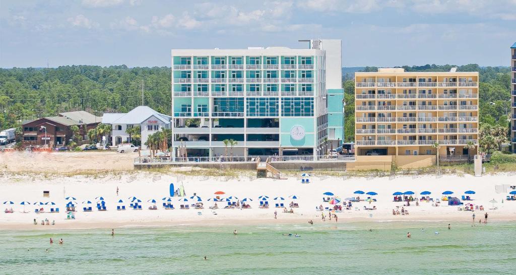 un gruppo di persone su una spiaggia con un edificio di Best Western Premier - The Tides a Orange Beach