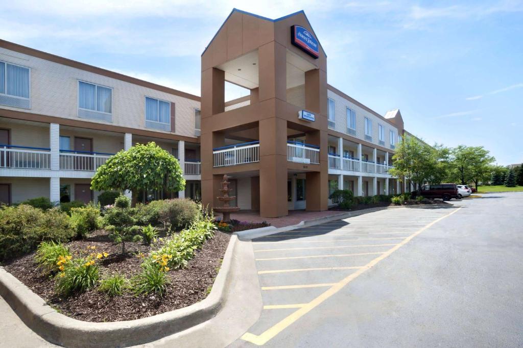 um edifício com uma torre de relógio num parque de estacionamento em Howard Johnson by Wyndham Romulus Detroit Metro Airport em Romulus