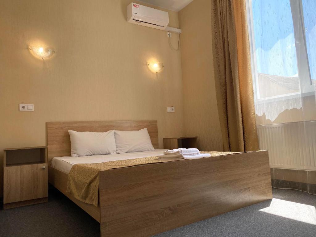 1 dormitorio con 1 cama y ventana grande en Guest House SOTNI, en Kiev