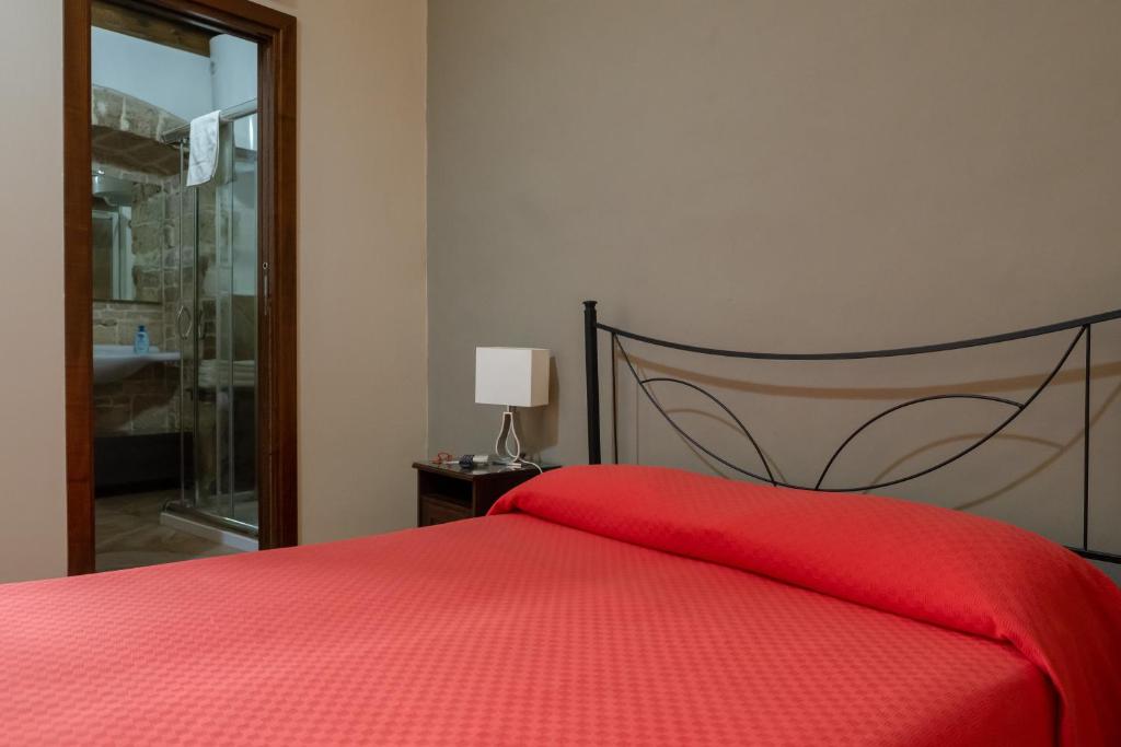 een slaapkamer met een rood bed en een rode deken bij B&B Santi Medici in Bitonto