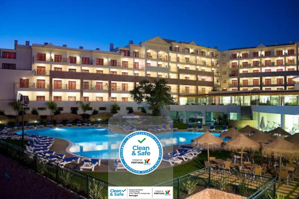 a hotel with a swimming pool and chairs and a building at Cerro Mar Atlantico & Cerro Mar Garden in Albufeira