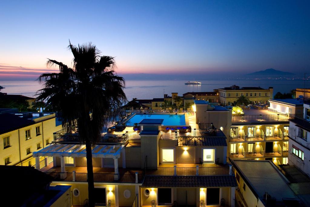 uitzicht op een stad in de nacht met een palmboom bij Grand Hotel La Favorita in Sorrento