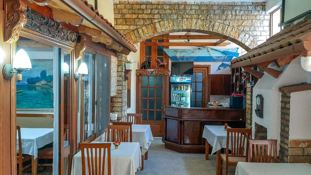 un restaurante con mesas y sillas en una habitación en Vila Korani, en Tirana