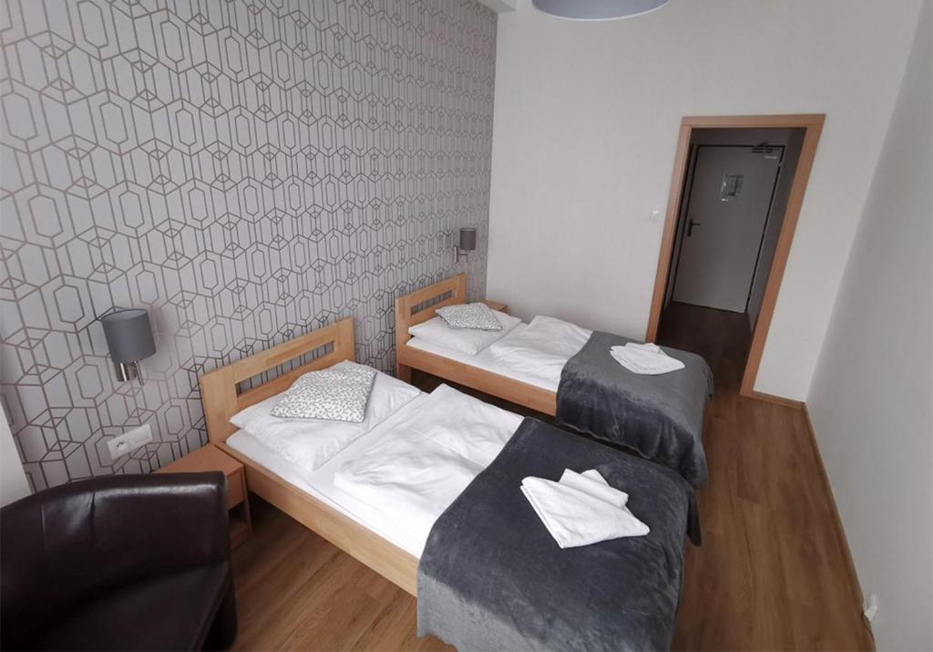 een kamer met 2 bedden en een stoel. bij Hotel Preveza in Spišská Nová Ves