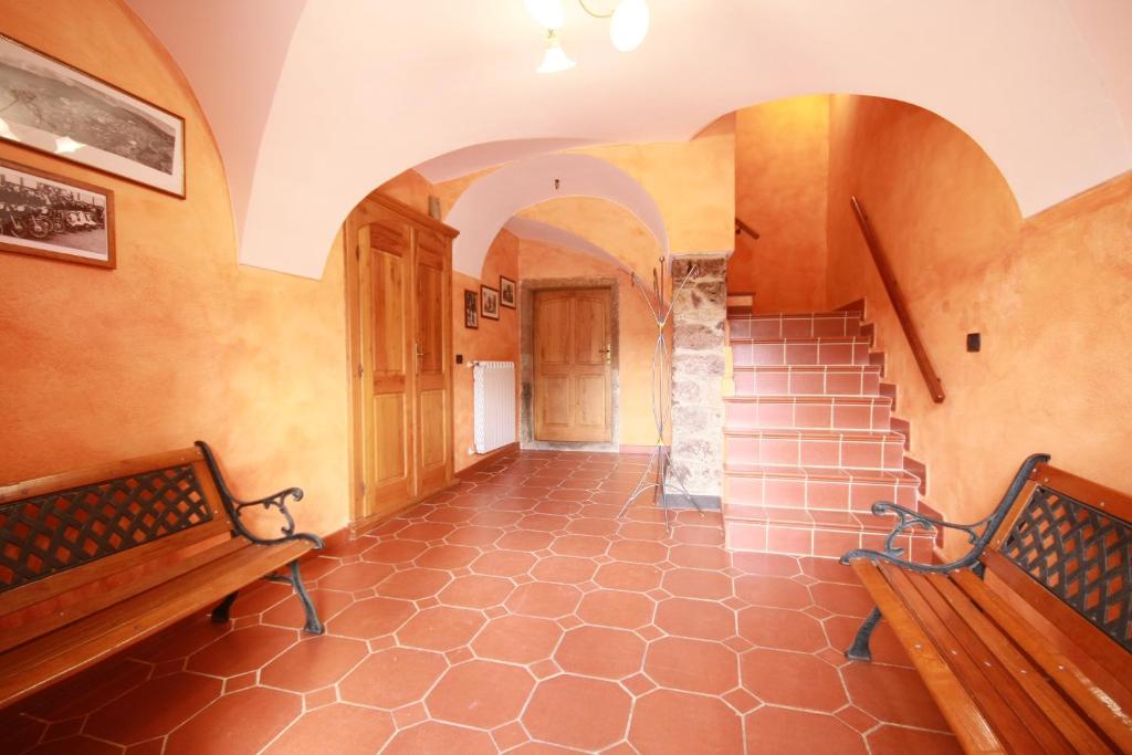 an empty hallway with two benches and a staircase at B&B Linu Ruiu in Santu Lussurgiu