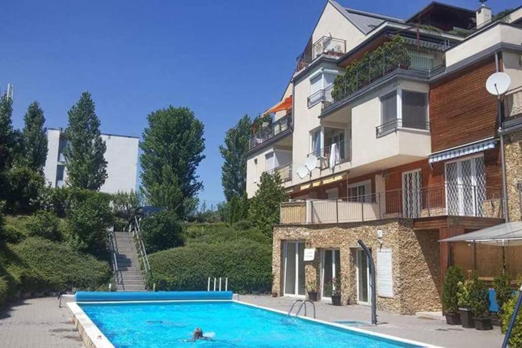 een huis met een zwembad voor een gebouw bij Peppy Apartment & Pool in Balatonfüred