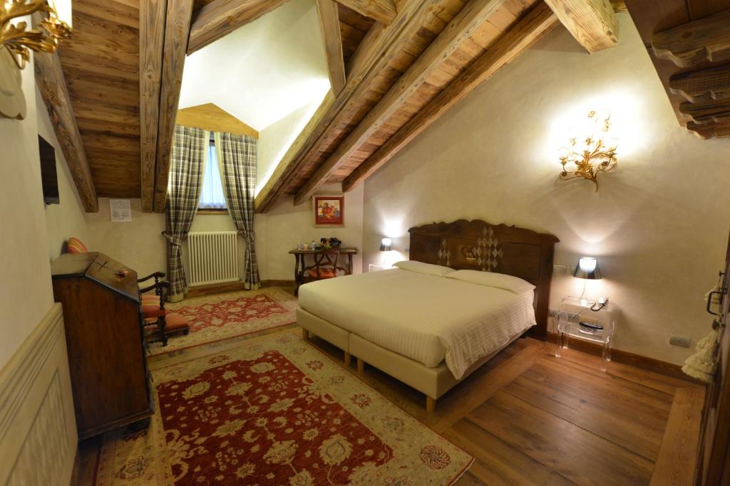 um quarto com uma cama grande e tectos em madeira em Le Reve Charmant em Aosta