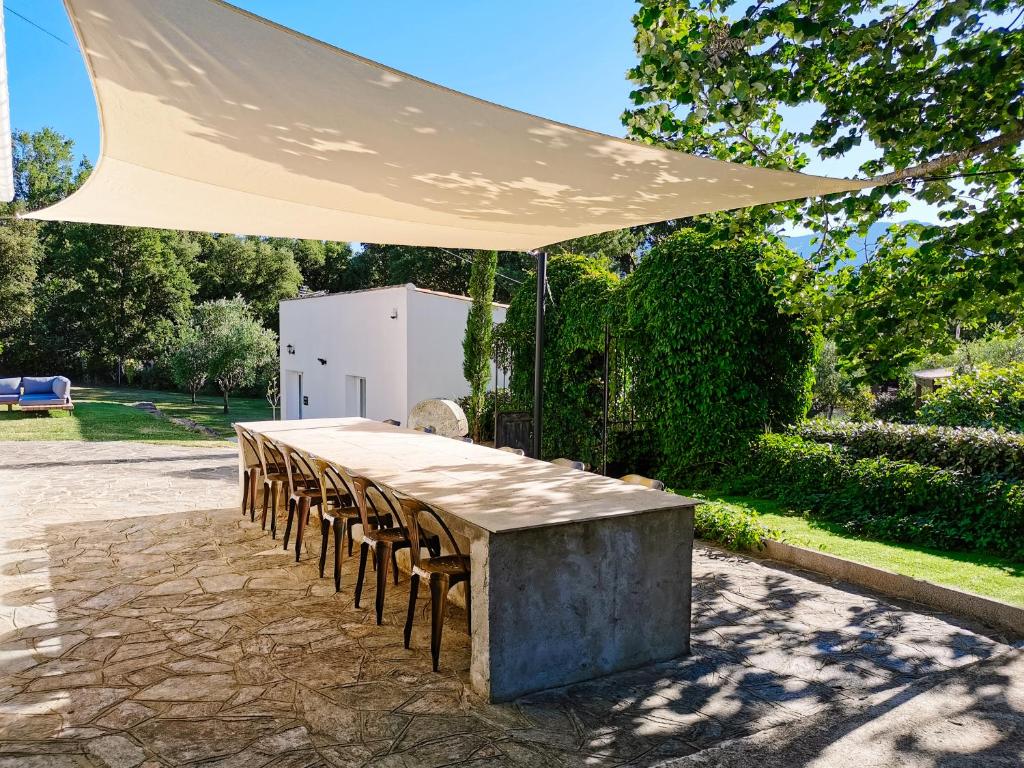 een tafel met stoelen onder een witte paraplu bij Maison San Giovanni in Corte