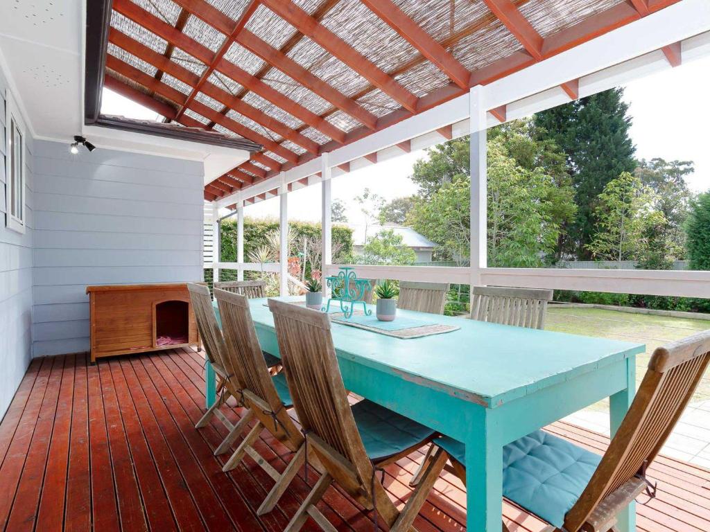 a patio with a blue table and chairs on a deck at Rubys Retreat, 44 Achilles Street - pet friendly, aircon, wifi & boat parking in Shoal Bay