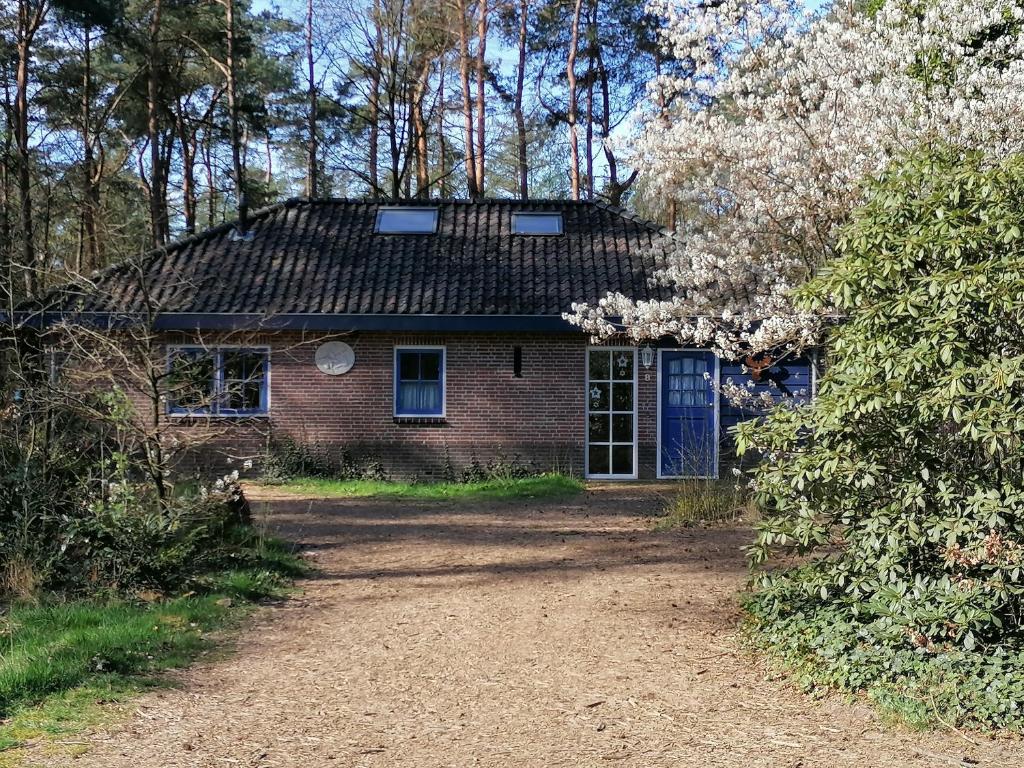 ein altes Backsteinhaus mit blauer Tür in der Unterkunft Holiday home bos en heide in Otterlo