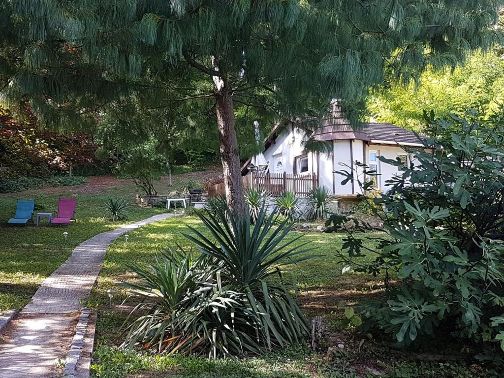 een huis in een tuin met een boom en een pad bij Ambition Zen Presles in Presles