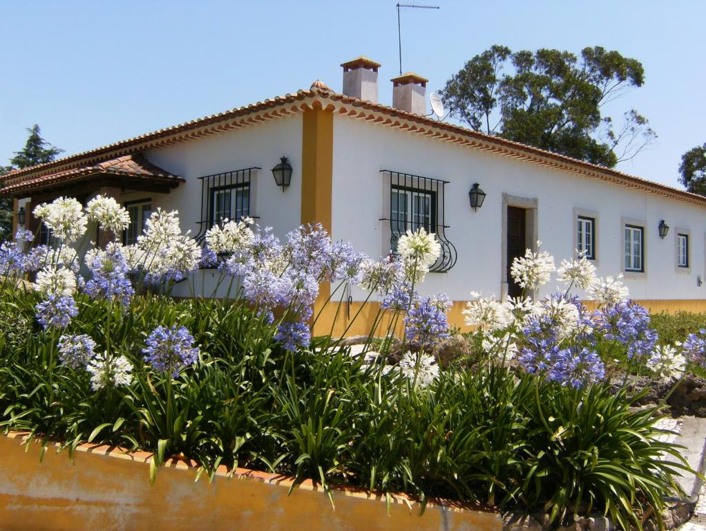 een huis met bloemen ervoor bij Quinta Da Torre - Óbidos Country House in Óbidos