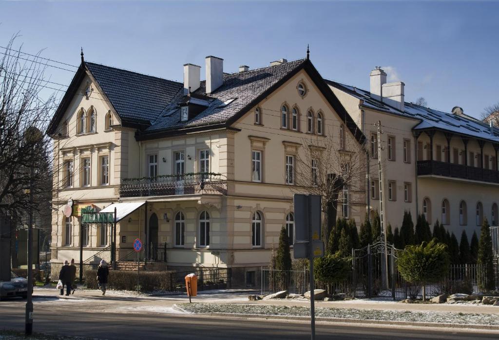 un grand bâtiment blanc avec un toit noir dans l'établissement Willa Zuzanna, à Kudowa-Zdrój