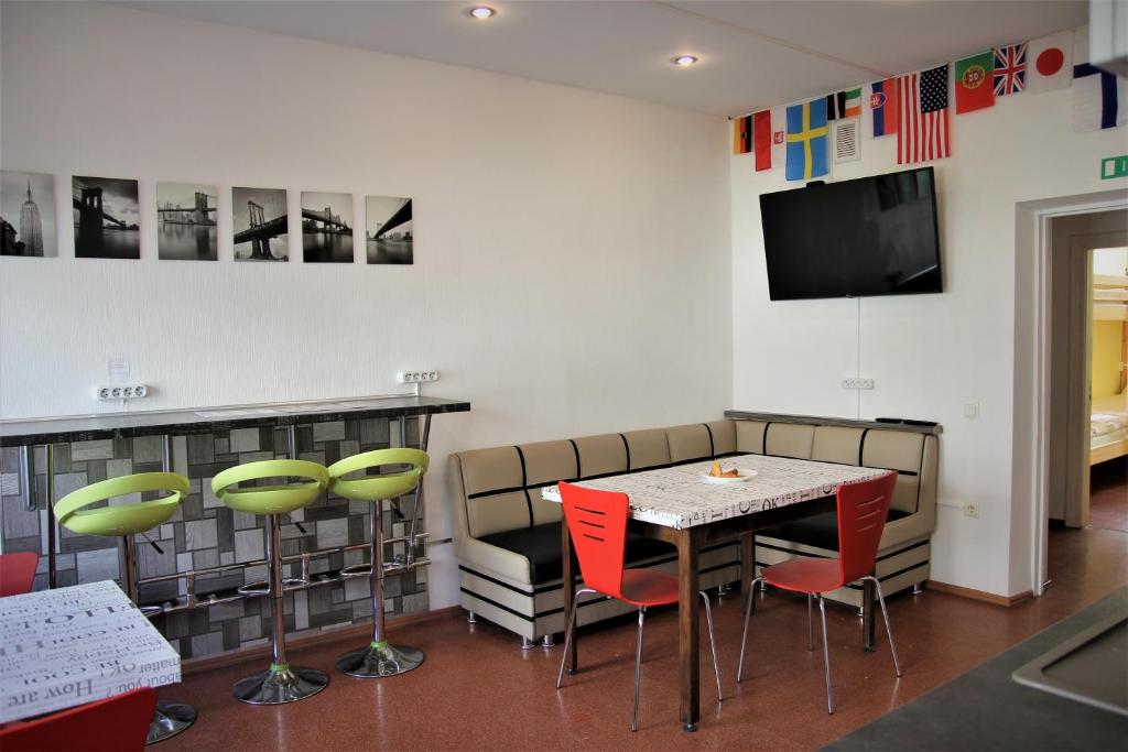 una sala da pranzo con tavolo, sedie e TV di Central Hostel Jelgava a Jelgava