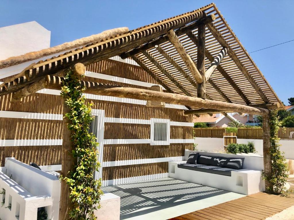 eine hölzerne Pergola mit zwei Sofas auf dem Deck in der Unterkunft Cabana 2 da Comporta in Comporta