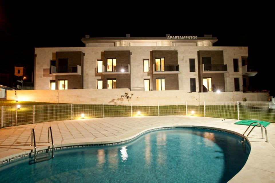 uma piscina em frente a um edifício à noite em Costa Quebrada Apartamentos em Soto de la Marina