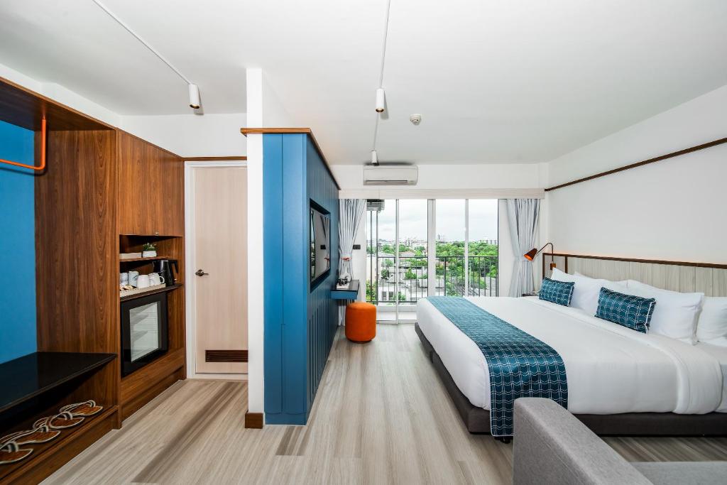 - une chambre avec un grand lit et une grande fenêtre dans l'établissement Hotel Amber Sukhumvit 85, à Bangkok