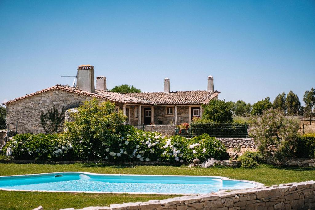 una casa con piscina frente a ella en Casas de Pedra - Quinta da Escola, en Alvados