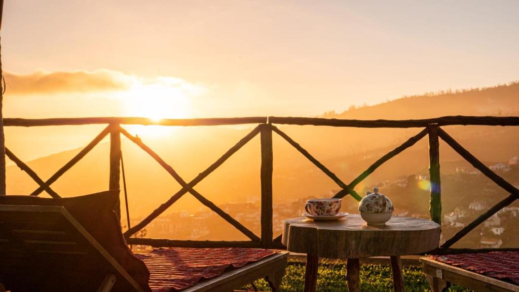 een tafel met een vaas bovenop een balkon bij Casa dos Avos in Calheta