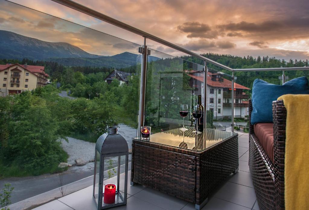 balcone con tavolo e bicchieri da vino di Apartament MOUNTSEA ,Karpacz Ogrodnicza a Karpacz