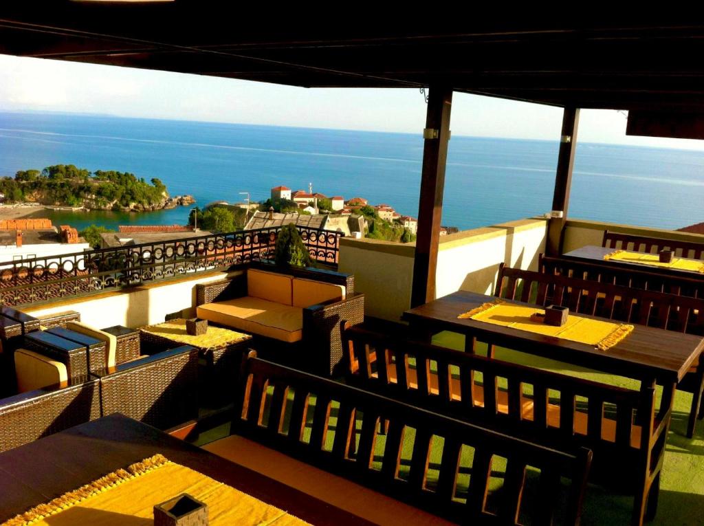 ein Restaurant mit Tischen und Stühlen auf einem Balkon in der Unterkunft Apartments Tati in Ulcinj