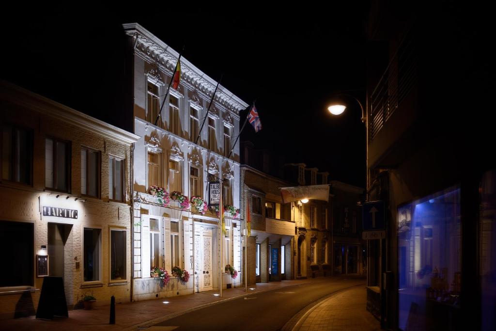 een verlicht gebouw op een straat 's nachts bij Talbot House in Poperinge