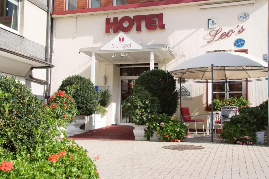 um hotel com uma mesa e um guarda-chuva em frente em Hotel Monopol em Gelsenkirchen