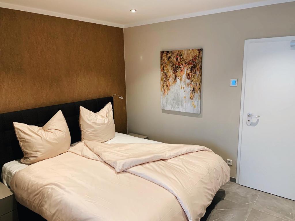 a bedroom with a bed with white sheets and a painting at OLÉ Hotel in Hamburg