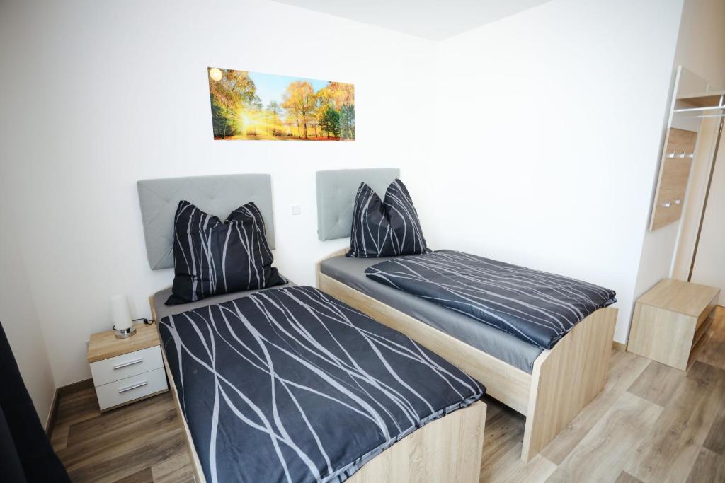 - une chambre avec 2 lits et un tableau mural dans l'établissement Second Home Hotel, à Merseburg