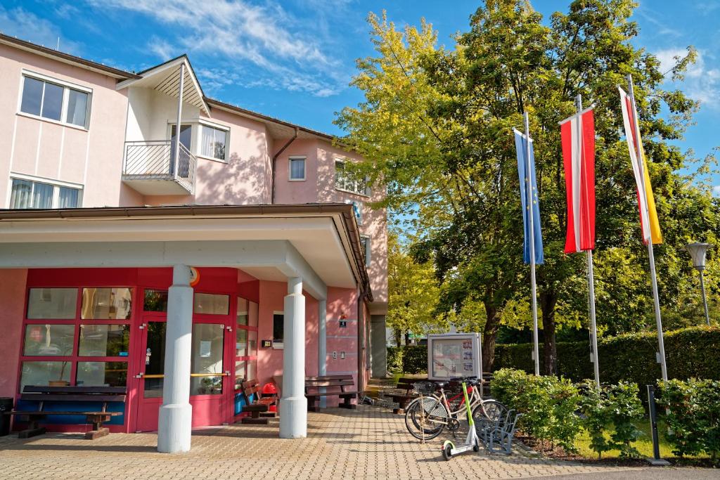 un ristorante con bandiere di fronte a un edificio di Jugend- und Familiengästehaus Klagenfurt a Klagenfurt