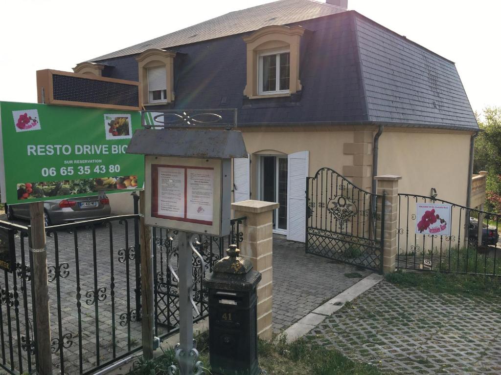 une maison avec un panneau devant une clôture dans l'établissement Orchidee Rose, à Givet