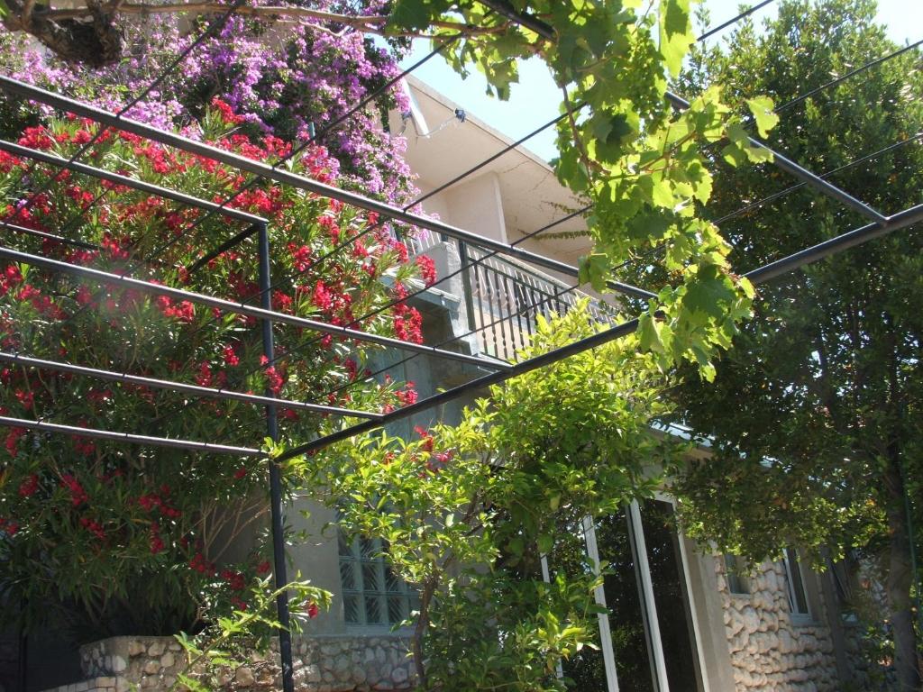 uma casa com flores cor-de-rosa numa varanda em Apartments Stari Pavle em Brela