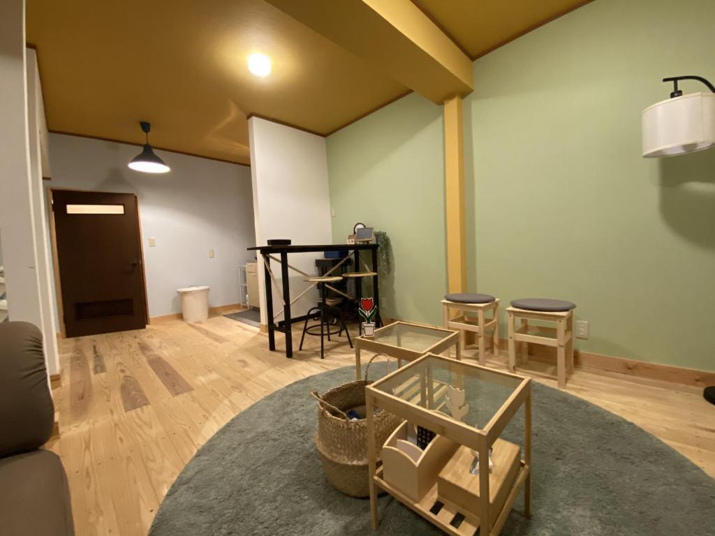 een woonkamer met een tafel en stoelen bij mooi guesthouse 日新町 in Aizuwakamatsu