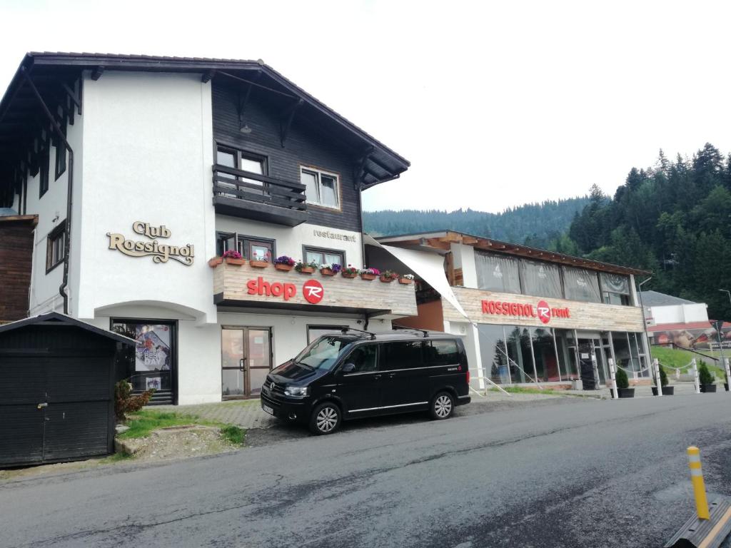 un furgone nero parcheggiato di fronte a un edificio. di Club Rossignol a Poiana Brasov