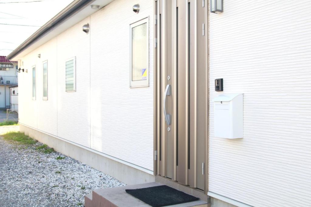 een deur aan de zijkant van een wit gebouw bij Chiba - House - Vacation STAY 87410 in Chiba