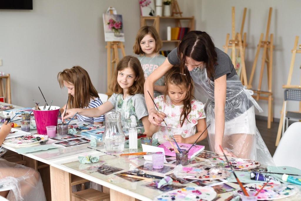 um grupo de crianças sentadas à mesa fazendo artesanato em Corner House em Odessa