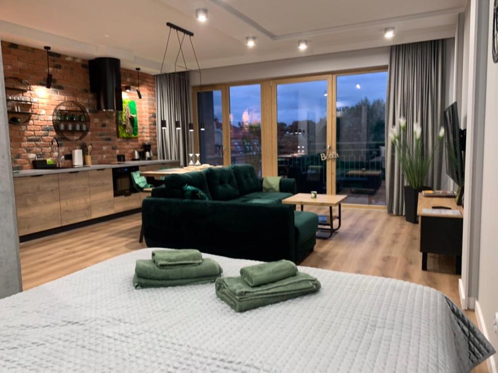 ein Wohnzimmer mit einem großen Bett mit grünen Kissen darauf in der Unterkunft Marina Green Loft-Apartament przy promenadzie in Lyck