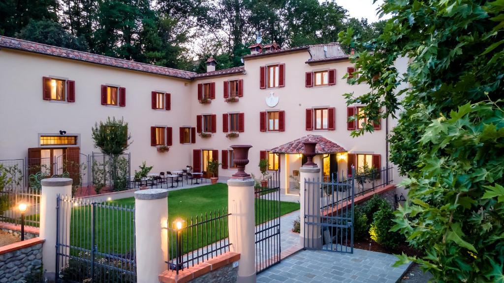 - une vue sur l'extérieur d'un grand bâtiment blanc avec une porte dans l'établissement Agriturismo Torreghiotta, à Pistoia