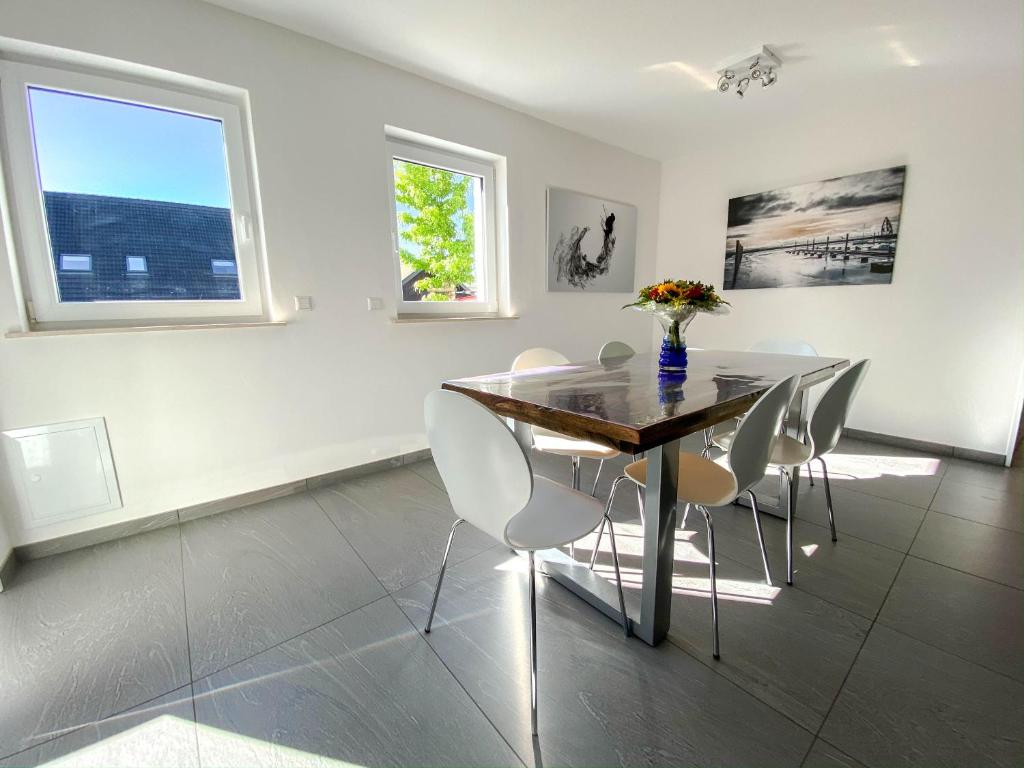 una sala da pranzo con tavolo e sedie di Apartment Schanzenstraße 690 m ü. M a Winterberg